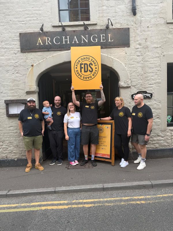 The FDS team holding a For Dads Sake sign outside the Archangel in Frome