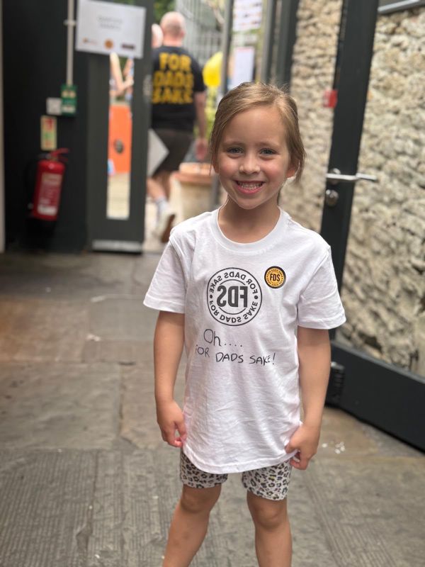 A girl in a white t-shirt with a hand-drawn FDS logo and the words Oh For Dads Sake
