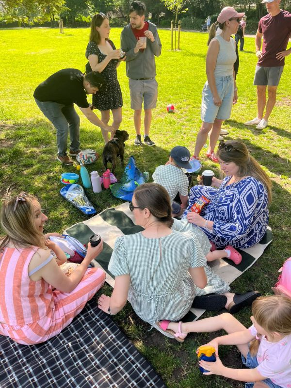 Families sitting on picnic blankets in the park