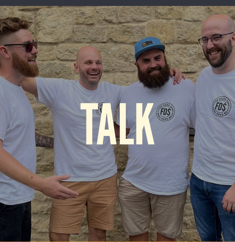 Four For Dads Sake founders laughing together against a stone wall