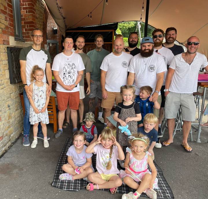 Dads and their children posing for a group photo at the first FDS coffee morning