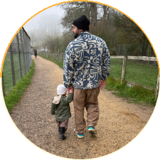 A dad walking hand in hand with his toddler